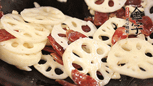 依次下香腸片、藕片翻炒均勻，加適量清水燜熟。