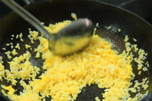 大火加熱炒鍋，再入油，燒到四至五成熱時(shí)倒入雞蛋液，在未凝結(jié)之前，加米飯煸炒，不停翻炒并用鍋鏟將成塊的米飯碾開、撥散。