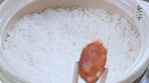 煮開后轉(zhuǎn)小火，當(dāng)米飯出現(xiàn)小孔時，鋪上金字麻辣香腸。