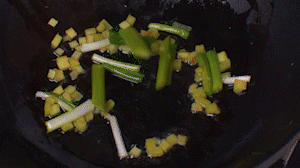 鍋中熱油，依次下姜粒、蔥段、蘆筍炒香。