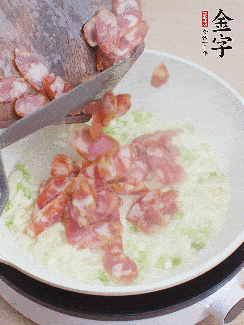 油5成熱，蒜末、蔥白爆香，下香腸炒出香味。