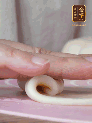 做面劑 油皮按扁，中間包入一個(gè)油酥，邊緣收緊捏死。包好的面劑按扁，用搟面杖搟壓成橢圓形。從底部向上卷成筒狀，用保鮮膜蓋好松弛15分鐘，再把筒狀縱向搟壓成長(zhǎng)條狀。再卷一次，松弛20分鐘