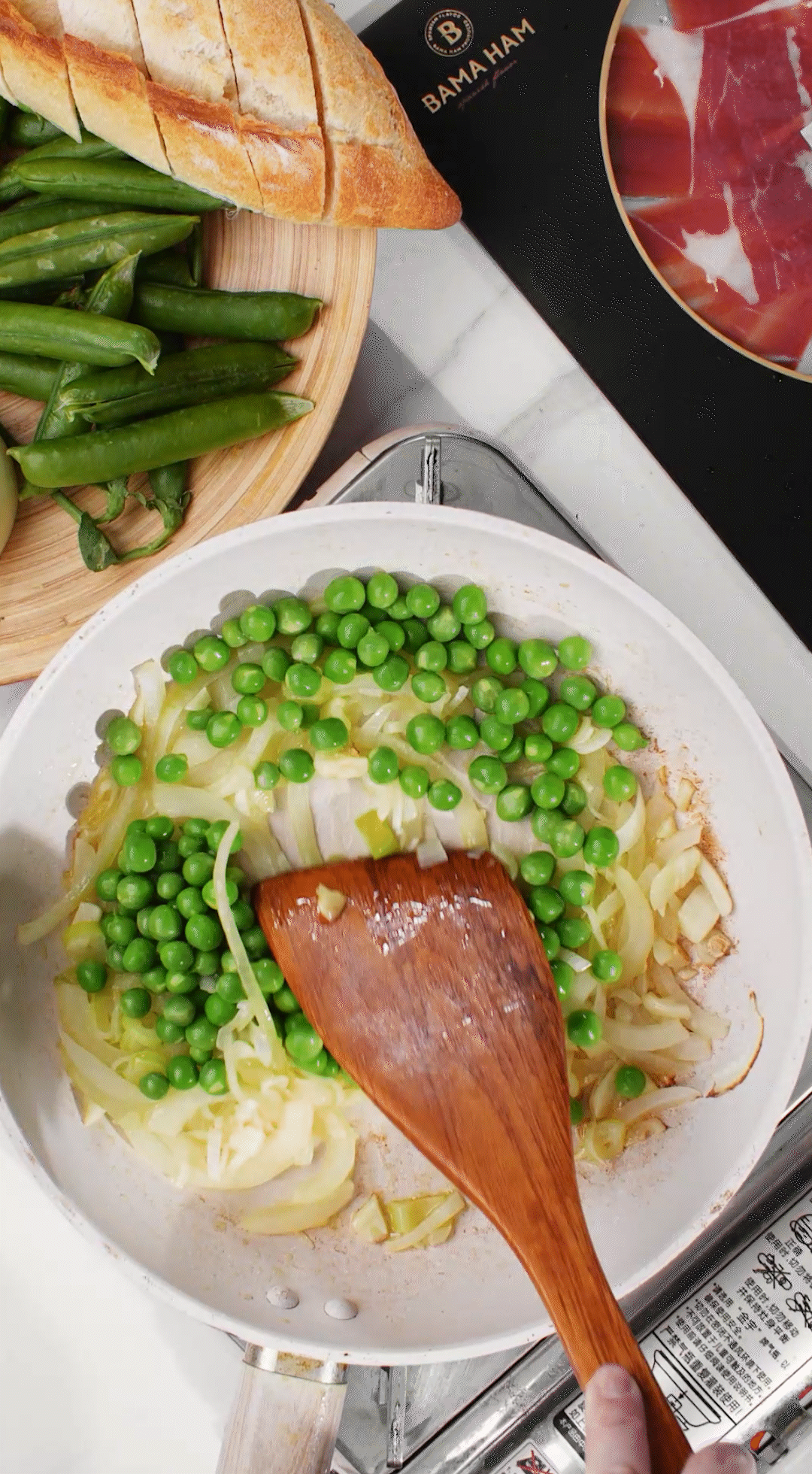 鍋中放入黃油融化，加入洋蔥絲、大蔥蔥白絲、蒜末翻炒變軟出香味。加入剛剛汆燙冰鎮(zhèn)后的豌豆，取出一點點待會擺盤裝飾用。加一點鹽 (和黑胡椒) 調(diào)味。