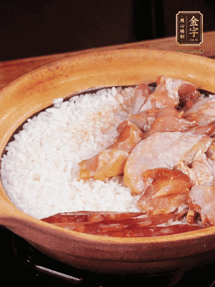 煮到椰子水微微收干轉(zhuǎn)小火，快速均勻鋪上雞肉、金字香腸