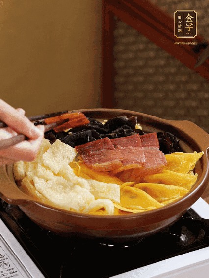 砂鍋底部鋪上娃娃菜，依次擺上肉皮、蛋餃、黑木耳、火腿